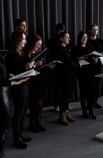Group of people in black outfits about to sing