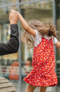 A child in a red dress with their parents