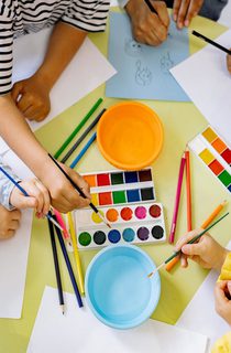 Children using pencils paint and colourful paint
