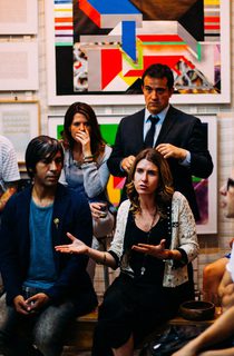 Group of people having a discussion with art on walls behind them