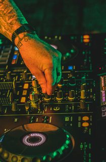 Electric mixing decks being operated by person with tattoos