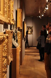 Patrons looking at art in gold frames