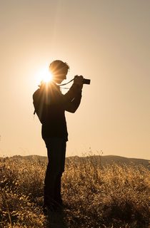 Person taking photographs in an empty field