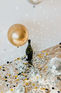 Golden confetti and disco balls with champagne bottle on the floor