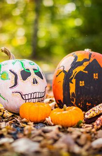 Ears of corn and pumpkins painted like a skull and haunted house