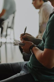 Person sitting in a chair taking notes on paper