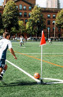 Man playing in a football match doing a corner kick