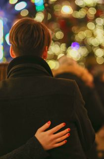 Couple looking out over Christmas outdoor gathering