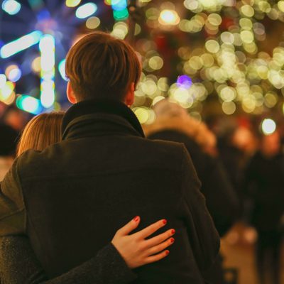 Couple looking out over Christmas outdoor gathering