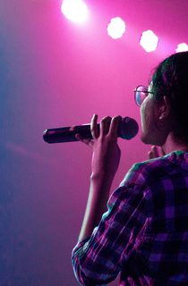 Woman onstage holding a microphone