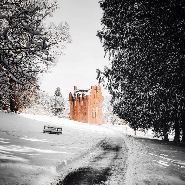 A castle standing against a backdrop of rolling hills and set within its own glorious gardens C